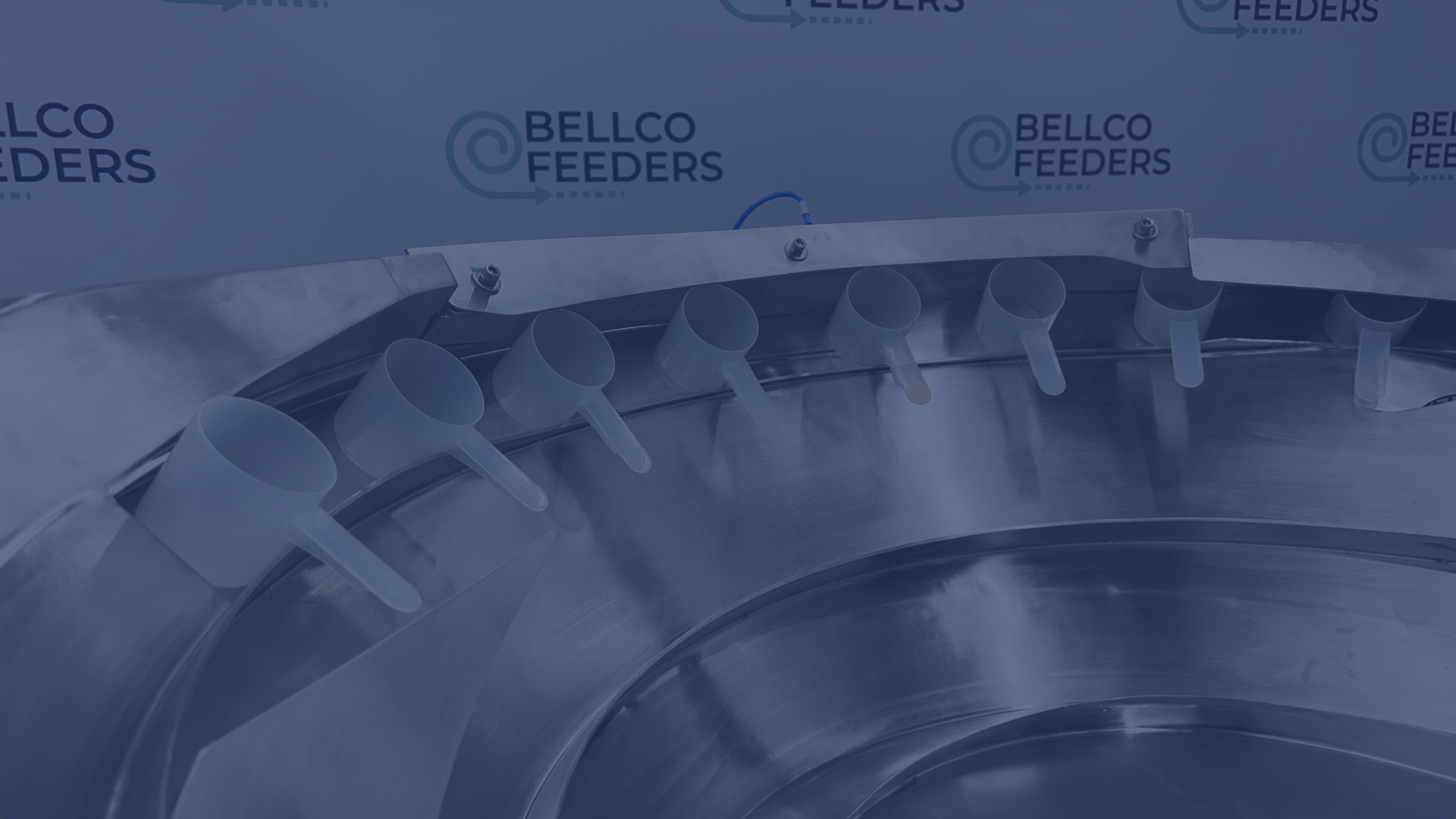 Image of plastic scoops oriented in a line inside a vibratory bowl feeder
