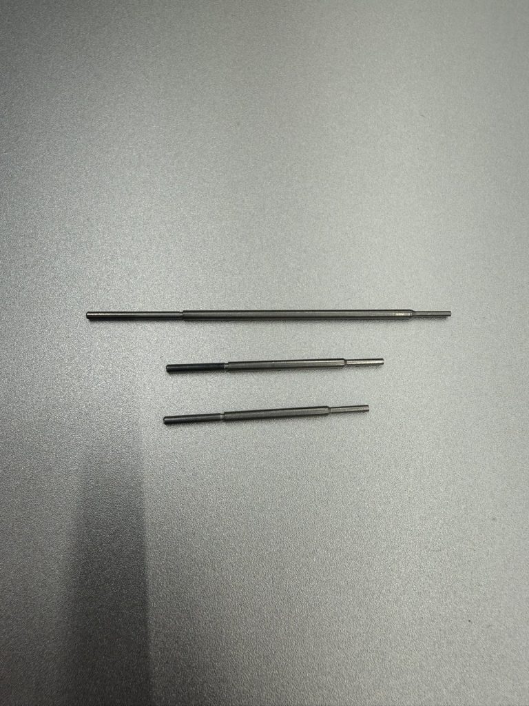 Three sizes of dual-pointed actuator pin, each with a tapered end and a cylindrical end, fed by a Bellco vision-guided step feeder