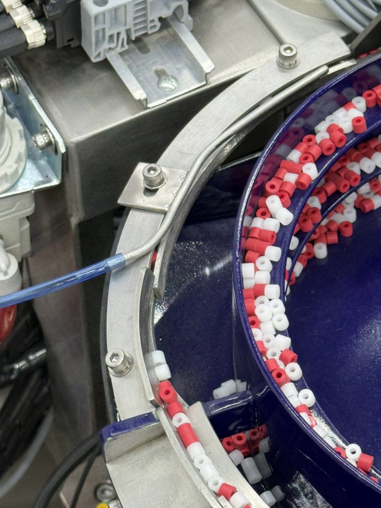 Close view of parts riding the tooled track of a polyurethane-coated Bellco vibratory bowl