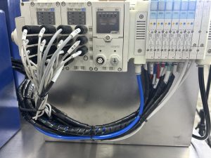 SMC pneumatic valve manifold and wiring inside a Bellco control enclosure