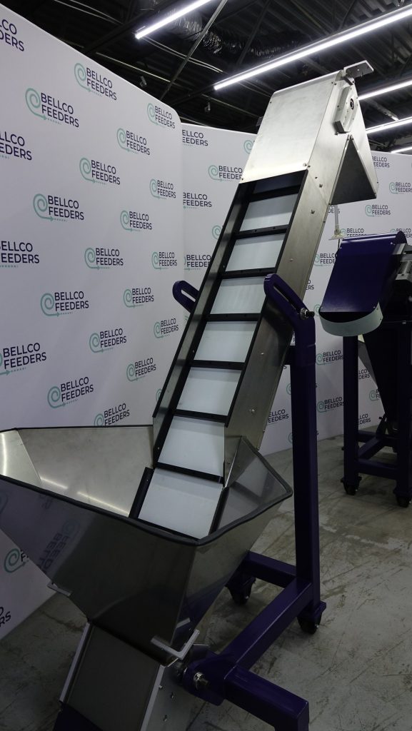 Bellco elevating conveyor hopper with a stainless bulk bin feeding a cleated incline belt