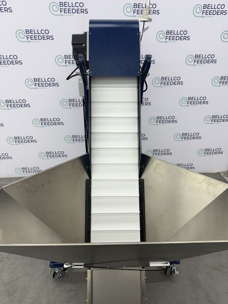 Bellco elevated conveyor hopper installed alongside a vibratory bowl feeder
