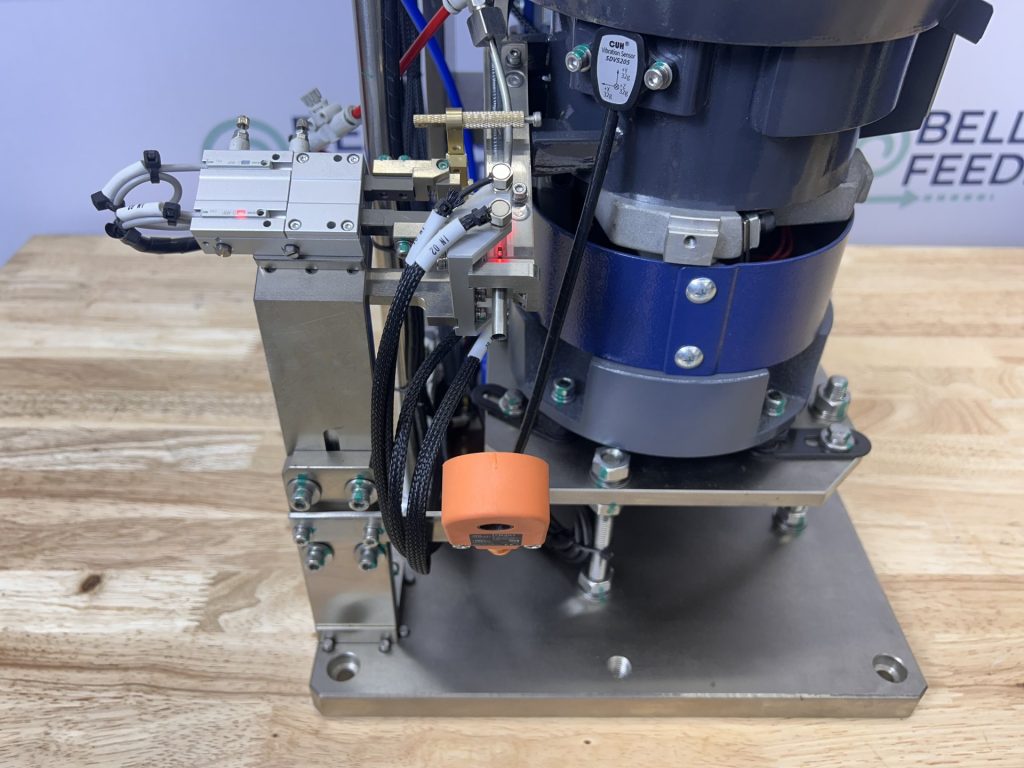 Bellco blow-feed escapement, which fires a singulated part down a tube to the assembly point using compressed air
