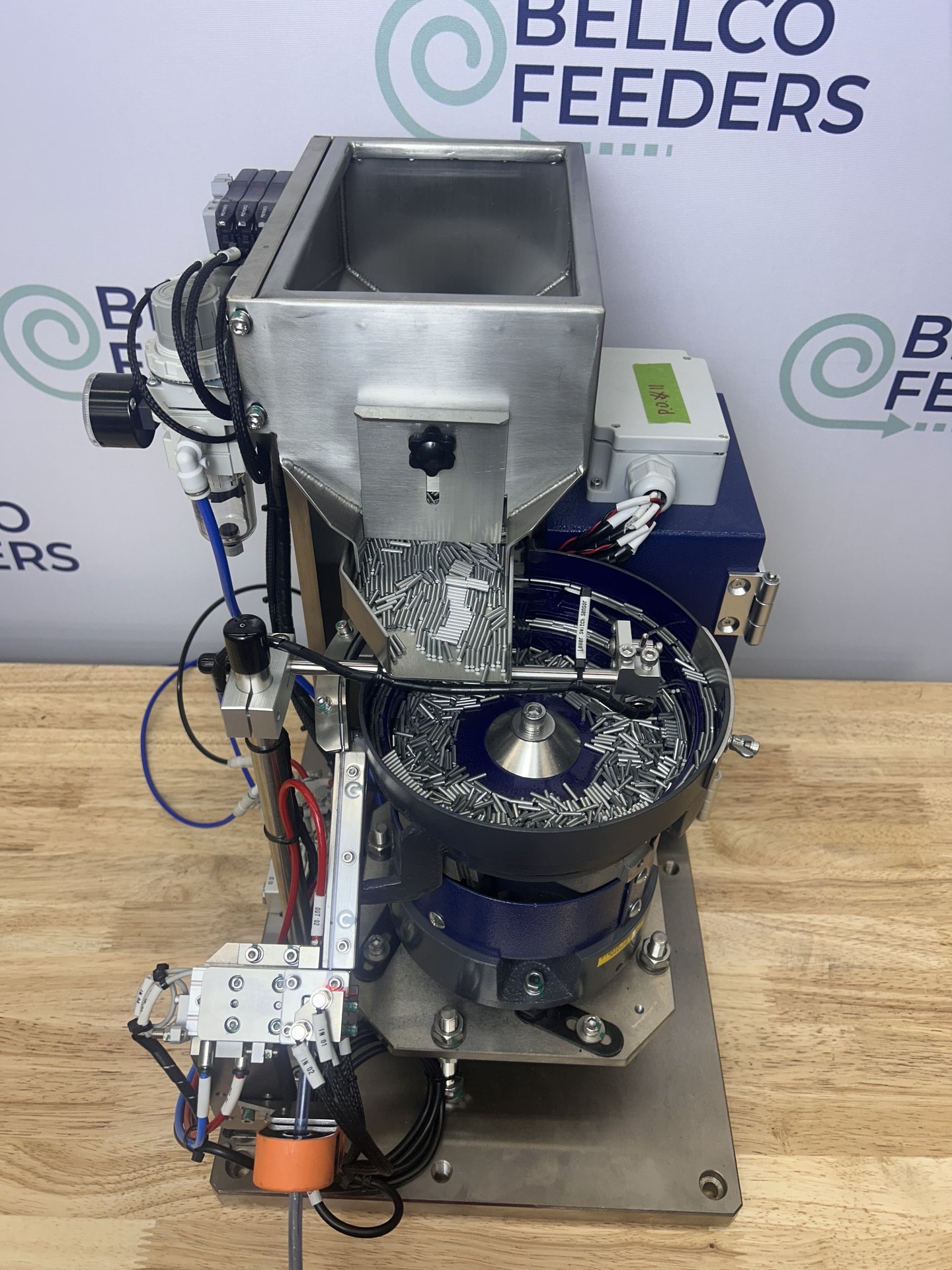 Compact Bellco bowl feeder with a blow-feed escapement and a stainless refill hopper on a single base plate