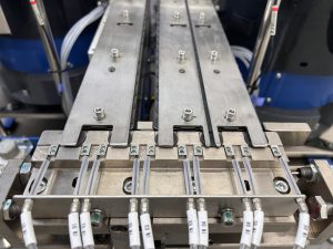 Four parallel escapement tracks on a single Bellco baseplate, each with its own pneumatic gate