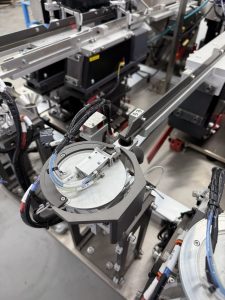 Bellco horizontal rotating escapement, which holds a singulated part in a fixed position for a robot to press out from below