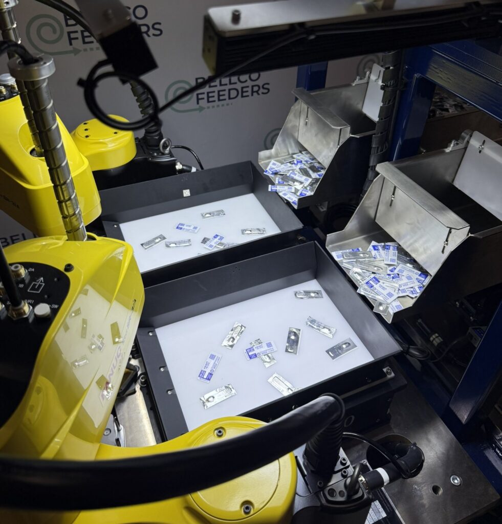 Two FANUC robots working over a Bellco Flex feeder platform in a vision-guided pick cell