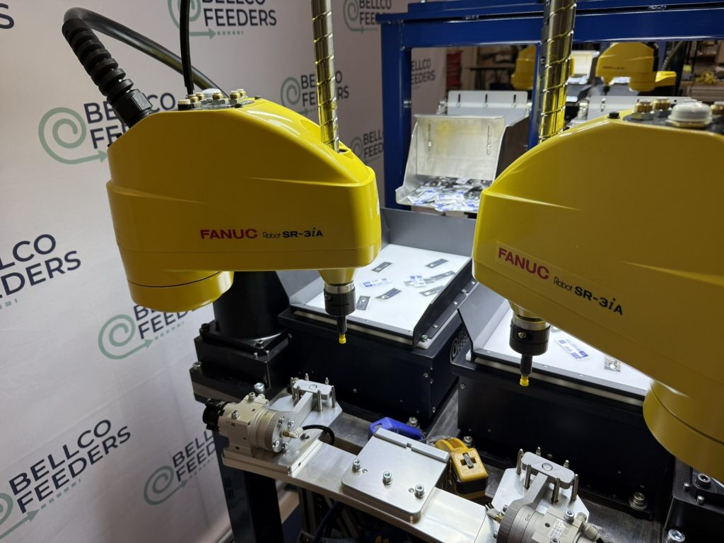 FANUC SCARA robot positioned above a Bellco Flex feeder, picking small parts from the lit platform