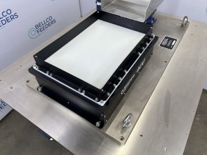 Overhead view of the backlit platform on a Bellco Flex feeder, which spreads parts out for a vision-guided robot