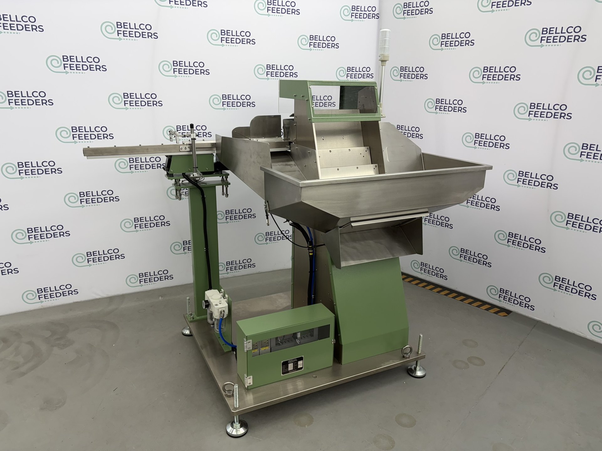 Side view of a Bellco step feeder showing the step elevating mechanism, green powder-coated frame and adjustable leveling feet
