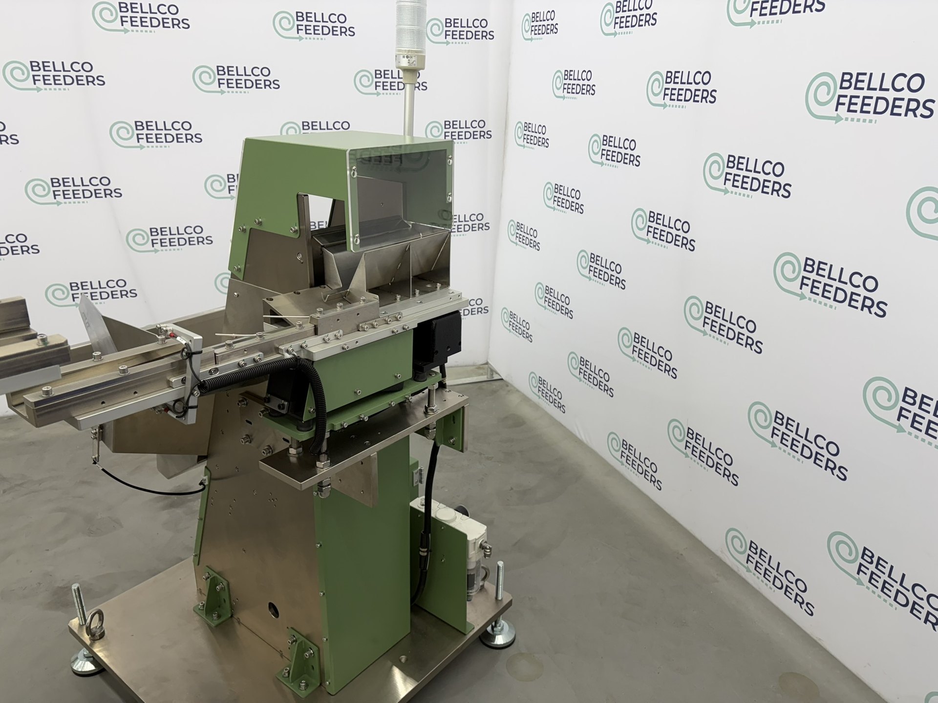 Bellco step feeder on rolling casters, positioned back-to-back with its twin in a production cell
