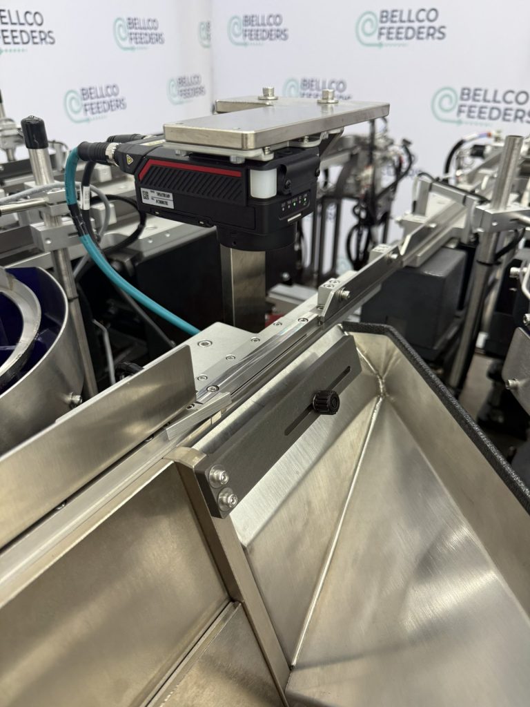 Bellco tabletop step feeder showing the vision camera housing mounted above the linear track