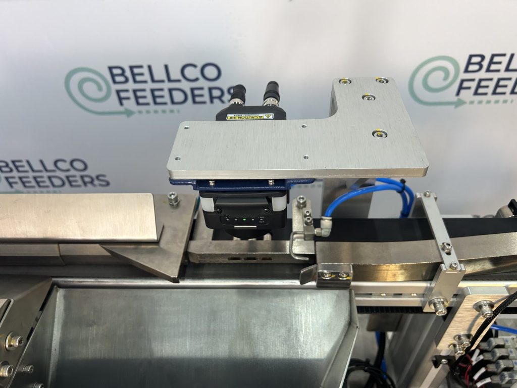 Vision camera and blow-off nozzle over a Bellco track, set up to reject any part running the wrong way round