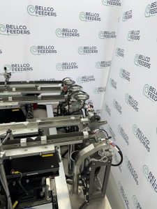Vision-guided Bellco feeding cell with overhead cameras inspecting parts in flight along the linear tracks