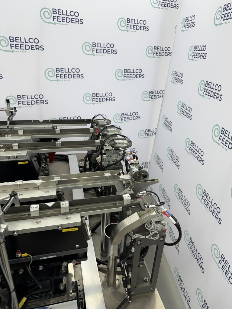 Vision-guided Bellco feeding cell with overhead cameras inspecting parts in flight along the linear tracks