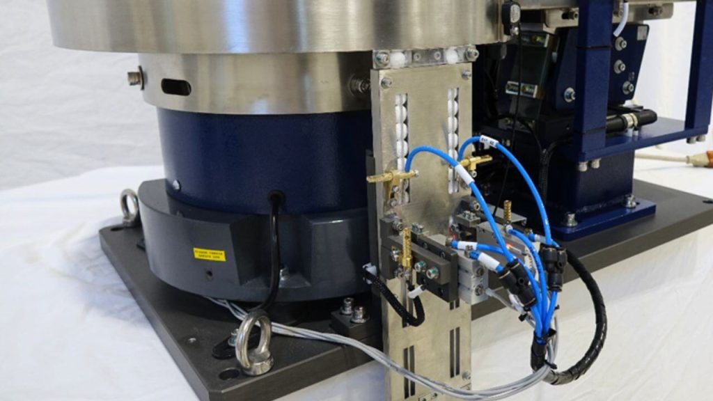 Dual-track escapement and pneumatics mounted beneath a stainless vibratory bowl feeder