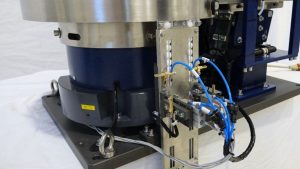Dual-track escapement and pneumatics mounted beneath a stainless vibratory bowl feeder