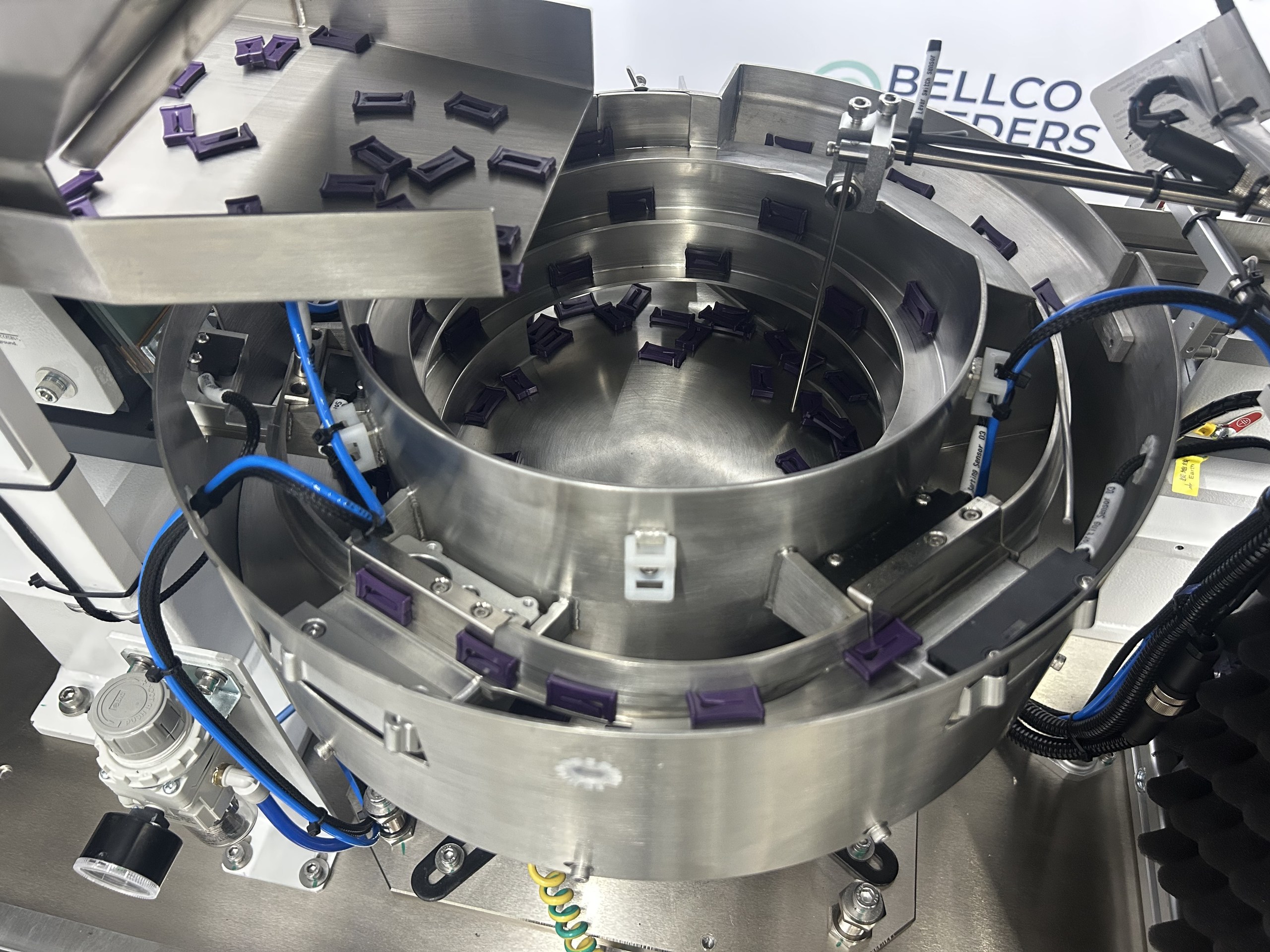 view of bulk hopper feeding plastic clips into vibratory bowl, using a keyence sensor for optimal flow